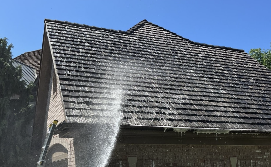 Roof Maxx spray treatment being applied to asphalt shingles on a home roof in Northeast Ohio