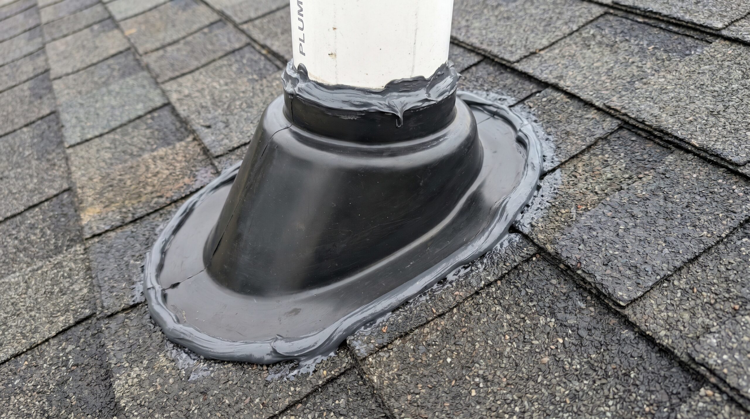 Detailed view of properly installed pipe boot around plumbing vent with weatherproof seal