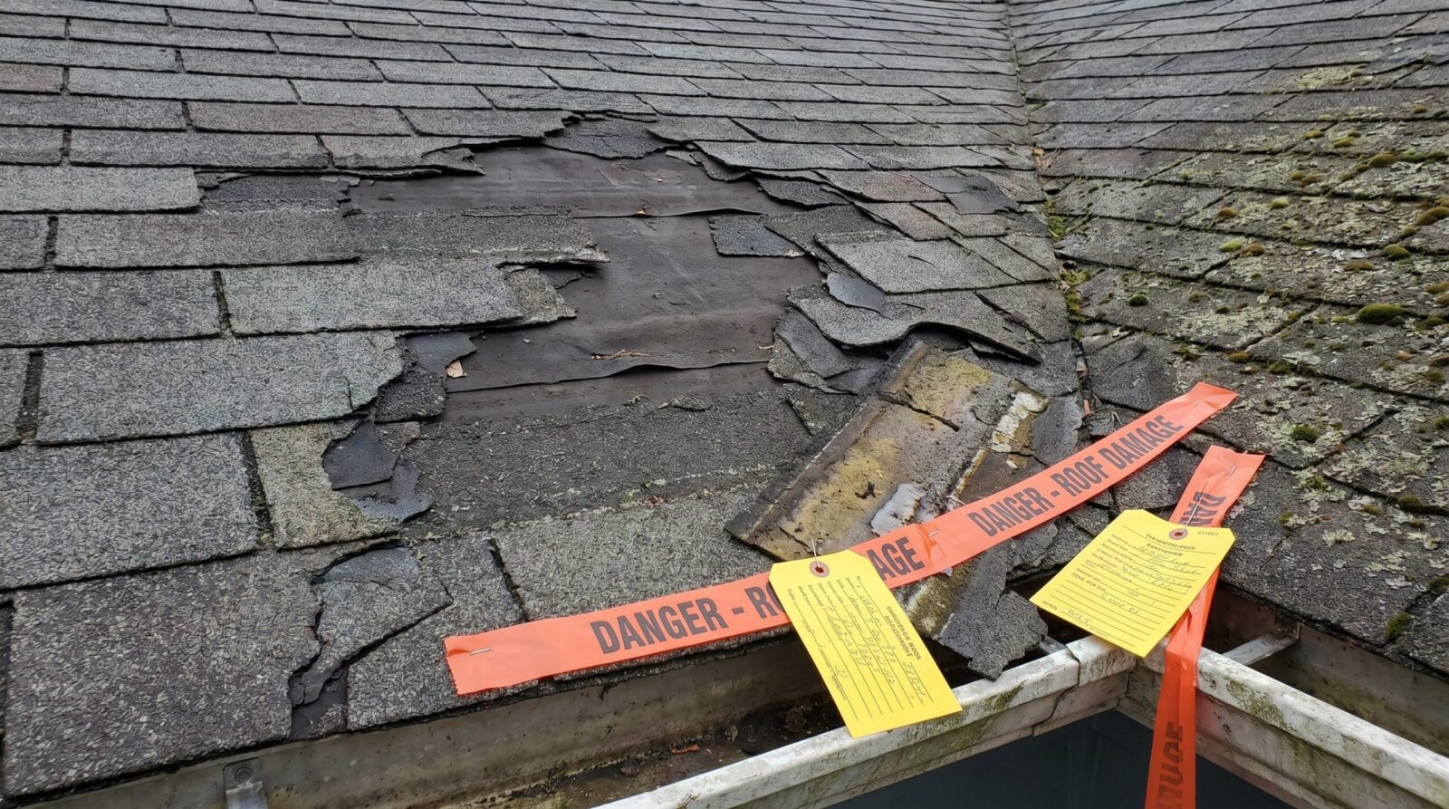 Damaged residential roof showing visible problems and inspection warning signs