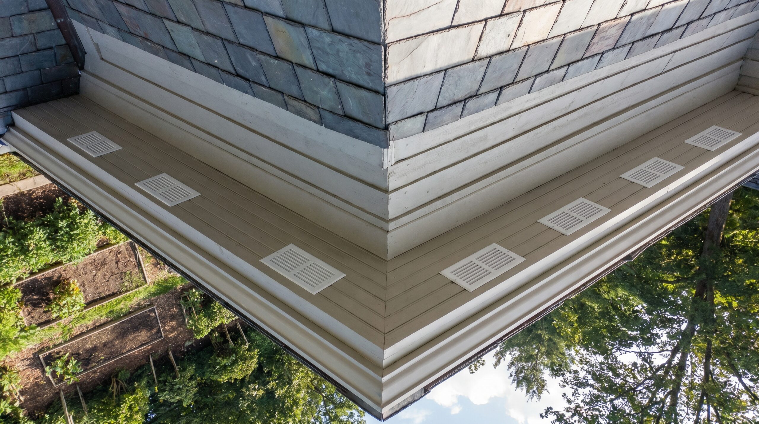 Overhead view of house eaves showing evenly spaced soffit vents along the perimeter