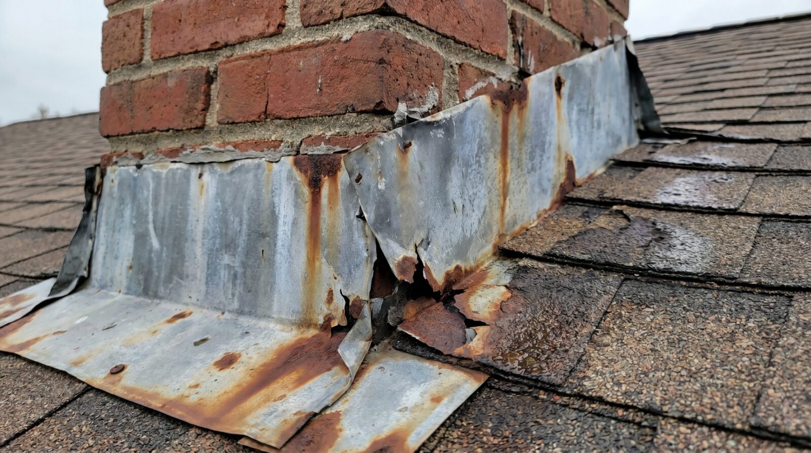 Close up of damaged roof flashing around chimney
